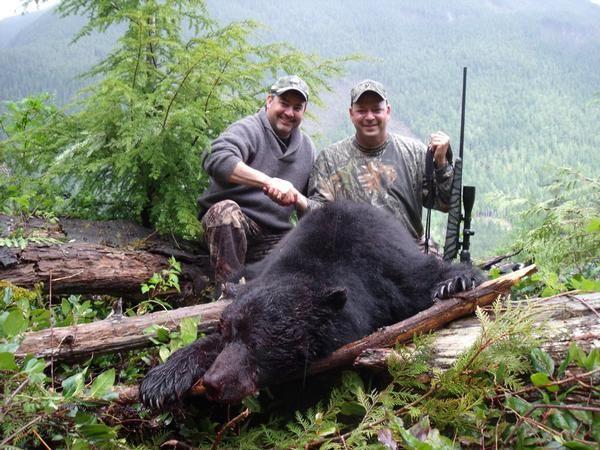 Darren DeLuca poses with a dead bear