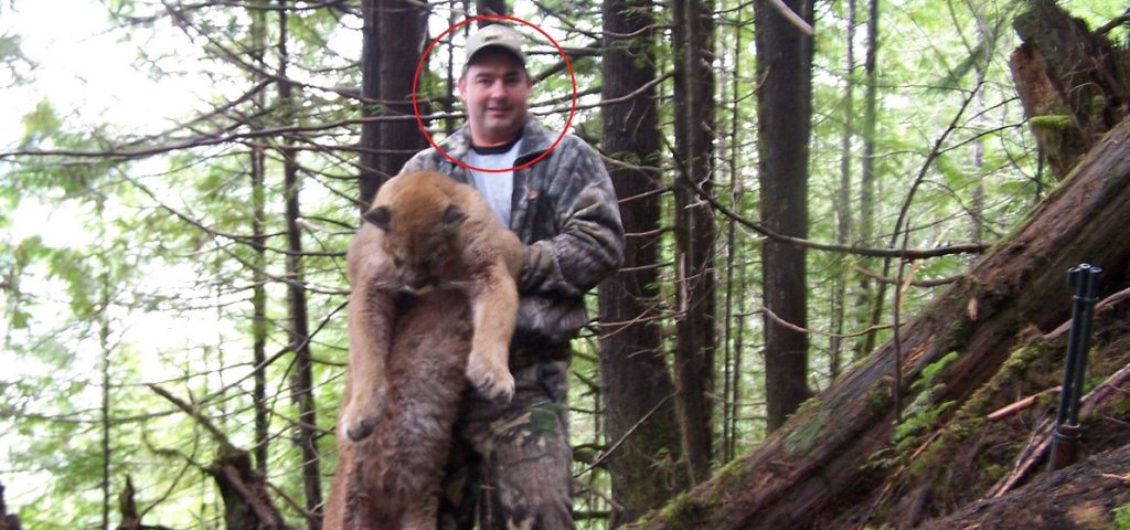 Darren DeLuca holds up a cougar