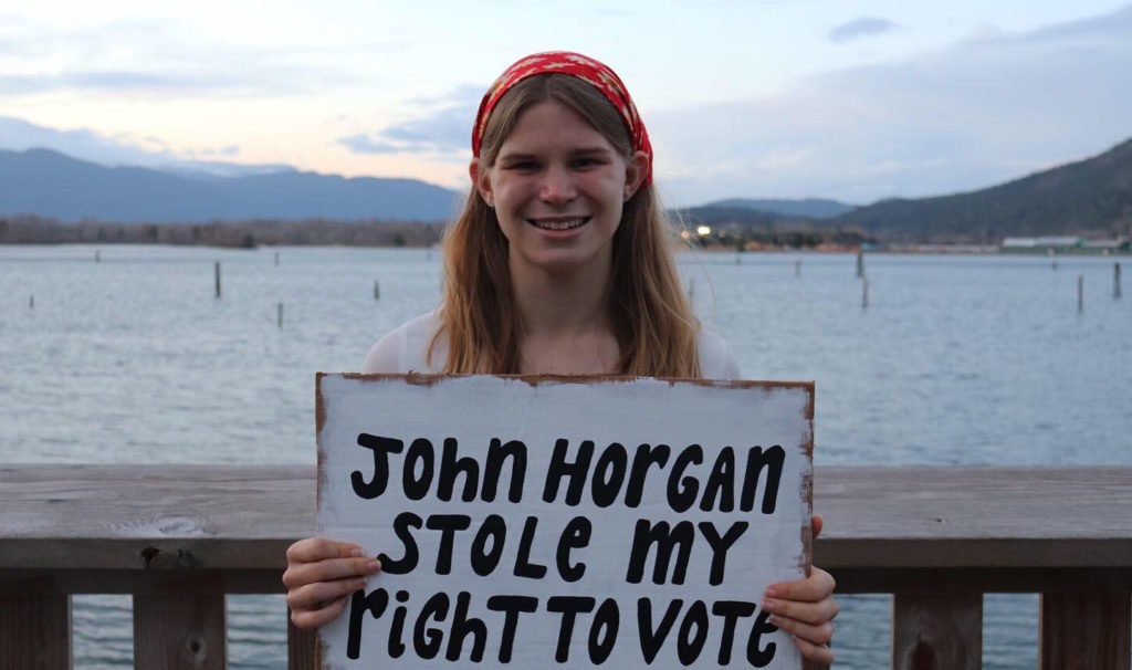 young woman holds sign that says "Horgan stole my vote."